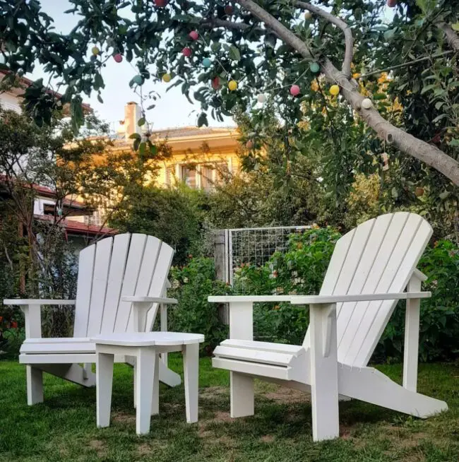 White Adirondack Chairs in a Verdant Garden