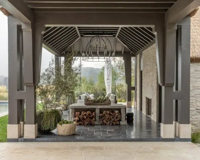 Rustic Covered Porch Featuring a Fireplace